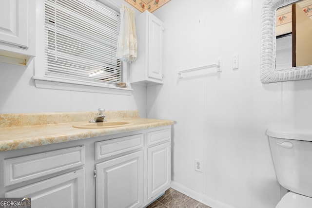 bathroom featuring tile patterned flooring, vanity, and toilet