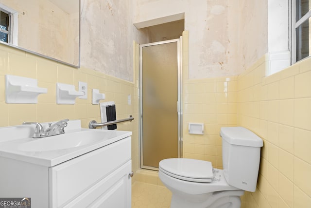 bathroom with vanity, an enclosed shower, tile walls, and toilet