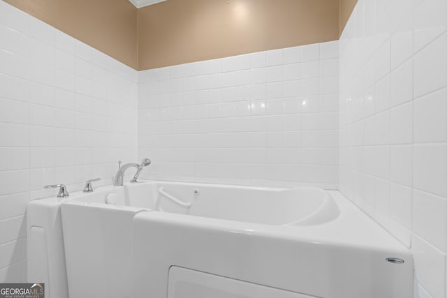 bathroom featuring a bathing tub and tile walls