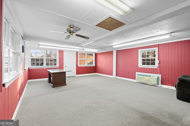 interior space with ceiling fan, carpet floors, and a wall mounted AC