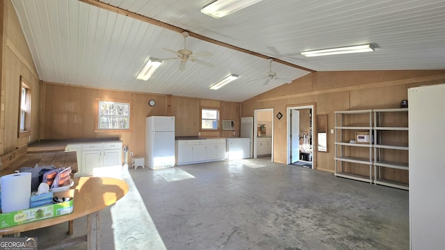 miscellaneous room with wooden walls, ceiling fan, concrete flooring, and vaulted ceiling