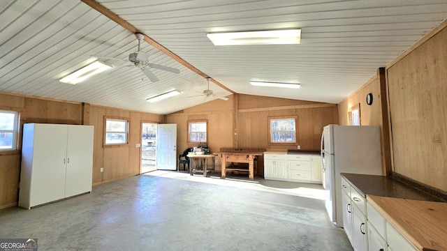 interior space featuring a wealth of natural light, white cabinetry, and wood walls