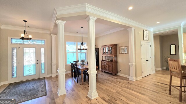 entryway with light wood-type flooring, an inviting chandelier, and crown molding