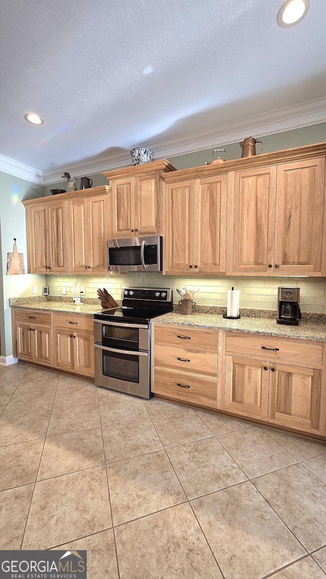 kitchen with decorative backsplash, light tile patterned floors, stainless steel appliances, and ornamental molding