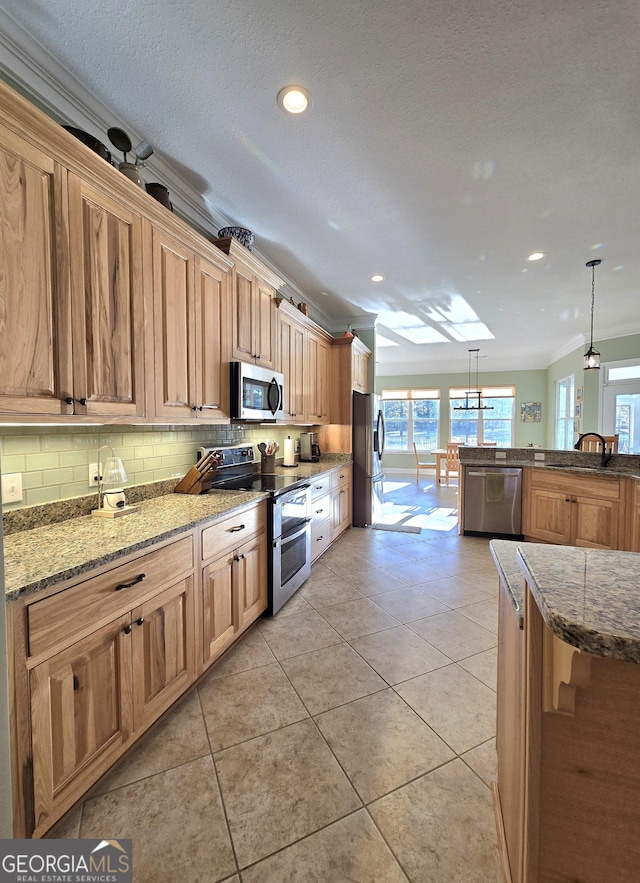 kitchen featuring backsplash, a skylight, light tile patterned floors, appliances with stainless steel finishes, and decorative light fixtures