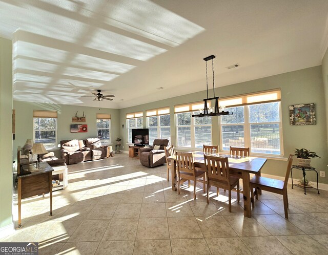 tiled dining area featuring ceiling fan with notable chandelier