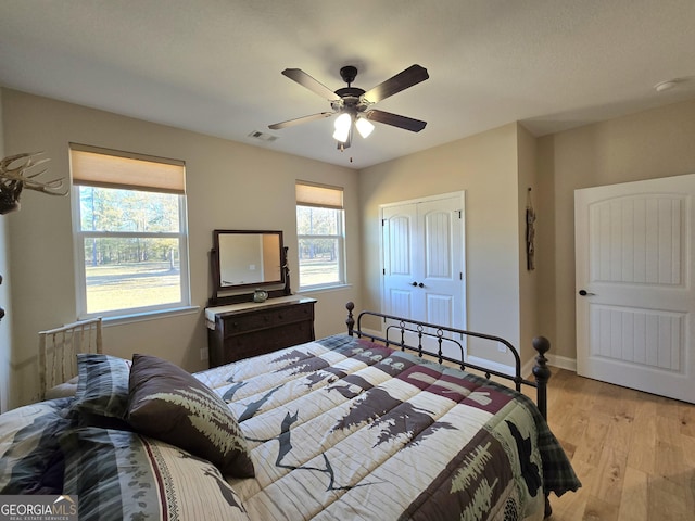 bedroom featuring ceiling fan, a closet, and light hardwood / wood-style flooring