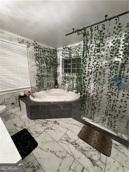 bathroom featuring tile walls and tiled tub