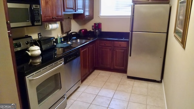 kitchen with light tile patterned floors, appliances with stainless steel finishes, and sink