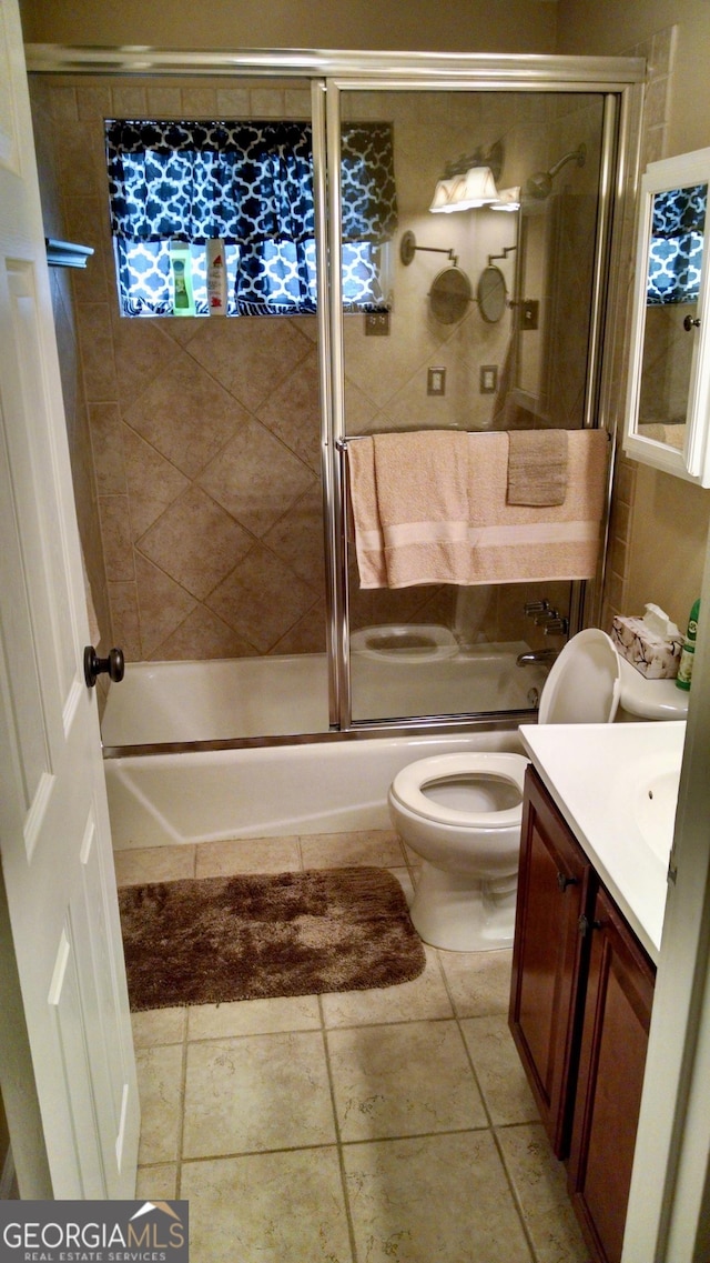 full bathroom with toilet, vanity, tile patterned floors, and shower / bath combination with glass door