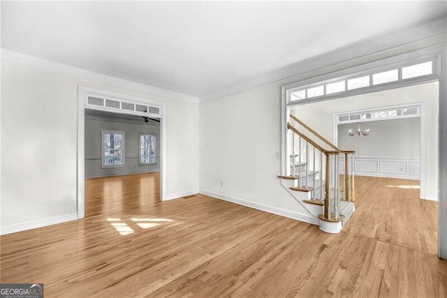 interior space featuring light hardwood / wood-style floors, an inviting chandelier, and ornamental molding