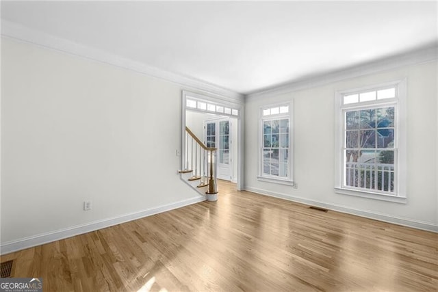 empty room featuring light hardwood / wood-style floors and crown molding