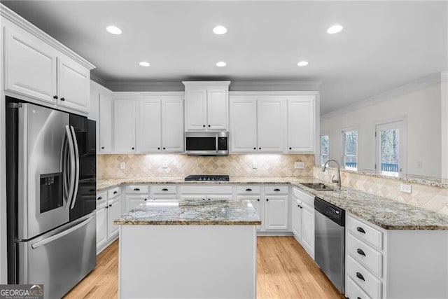 kitchen featuring sink, ornamental molding, appliances with stainless steel finishes, tasteful backsplash, and white cabinetry