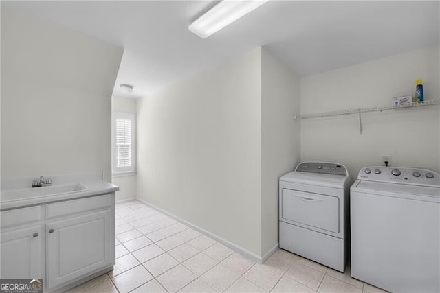 clothes washing area with washing machine and clothes dryer, sink, and light tile patterned floors