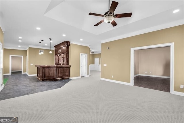 unfurnished living room featuring dark carpet, ceiling fan, and crown molding