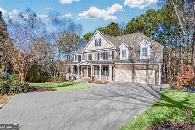 view of front of home featuring a front lawn, covered porch, and a garage