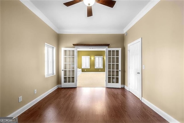 empty room featuring dark hardwood / wood-style flooring, crown molding, french doors, and ceiling fan