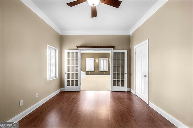 empty room featuring ceiling fan, ornamental molding, dark wood-type flooring, and french doors