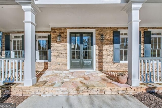 property entrance with covered porch and french doors