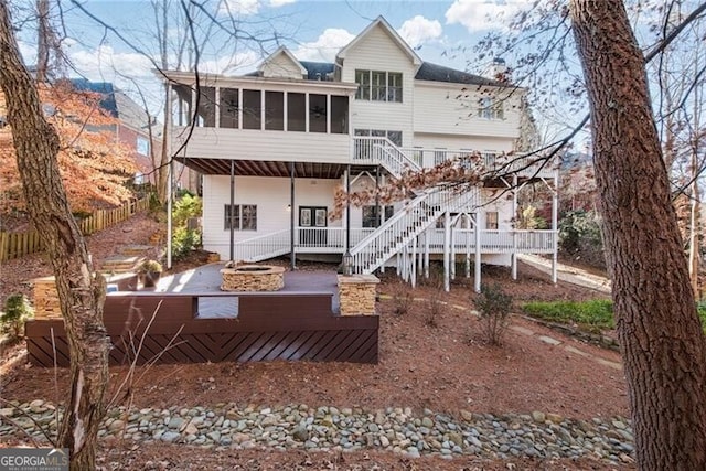 rear view of house with a wooden deck and a sunroom