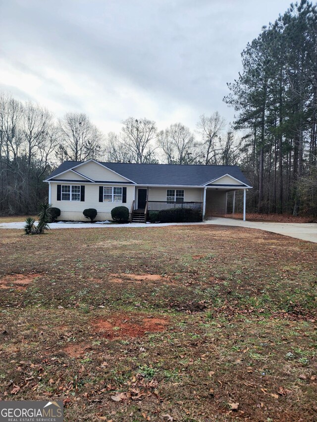 ranch-style home featuring covered porch and a carport