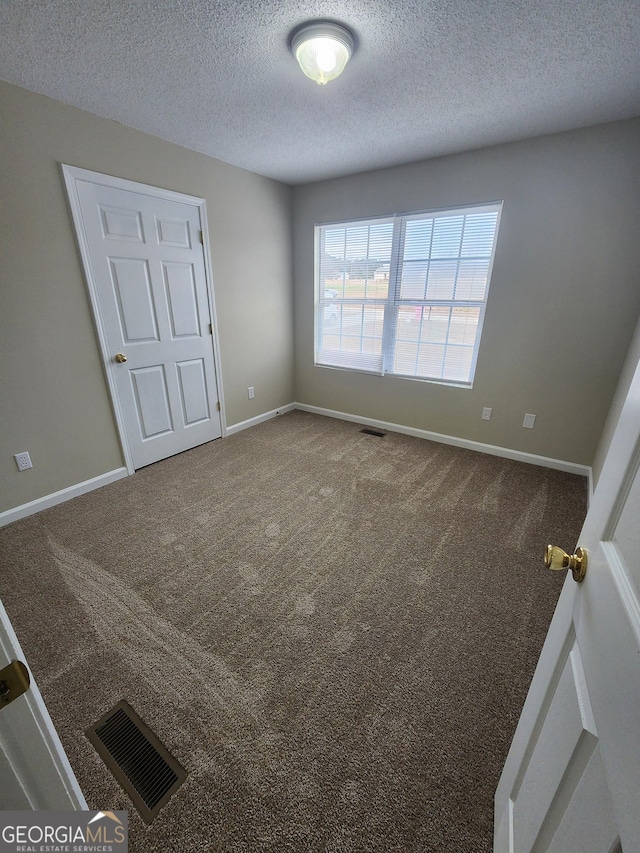 unfurnished room featuring carpet floors, baseboards, and visible vents