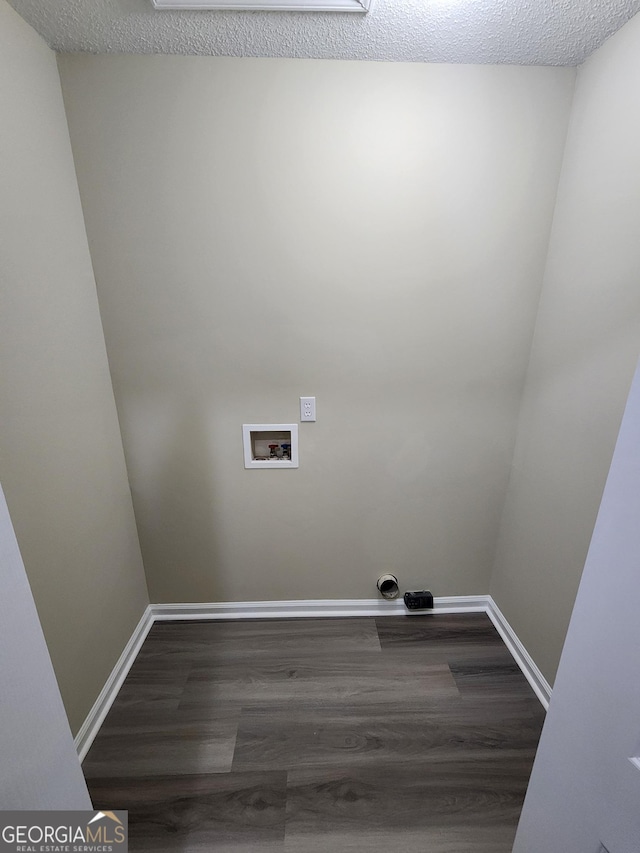 clothes washing area featuring dark wood-style floors, hookup for a washing machine, and baseboards