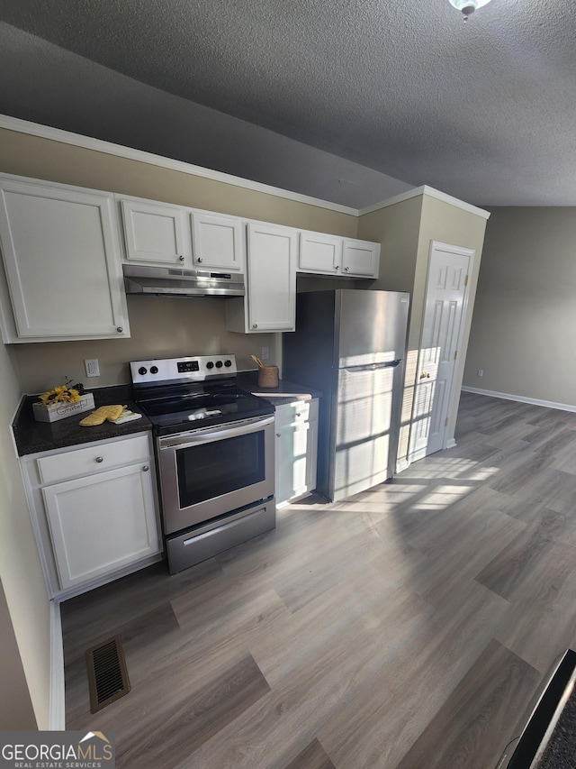 kitchen with visible vents, dark countertops, stainless steel appliances, under cabinet range hood, and white cabinetry