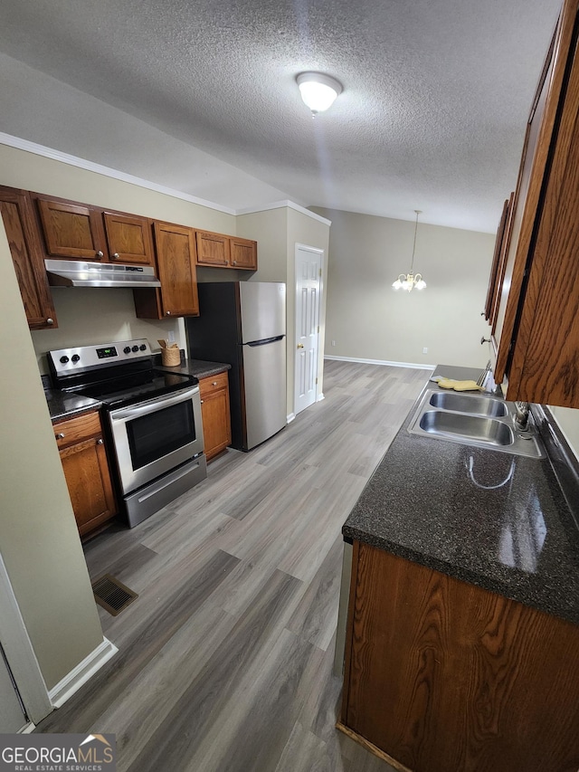 kitchen featuring appliances with stainless steel finishes, a textured ceiling, sink, wood-type flooring, and an inviting chandelier