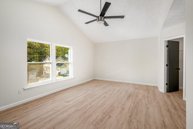 interior space featuring ceiling fan, light wood-type flooring, a textured ceiling, and high vaulted ceiling