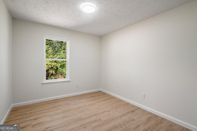 unfurnished room featuring light hardwood / wood-style floors and a textured ceiling