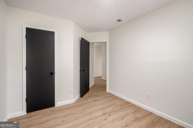 unfurnished bedroom with a textured ceiling and light wood-type flooring