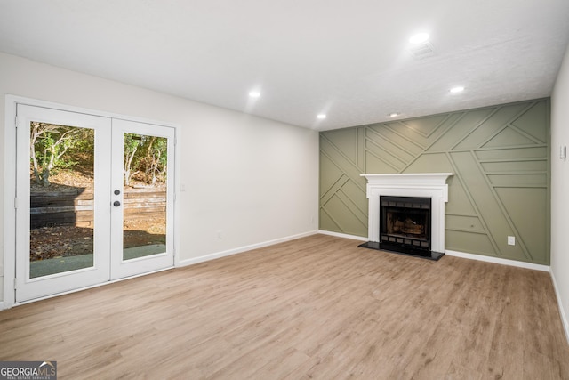 unfurnished living room with french doors and light wood-type flooring