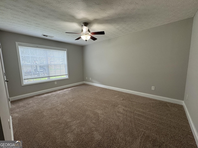 carpeted empty room featuring ceiling fan and a textured ceiling