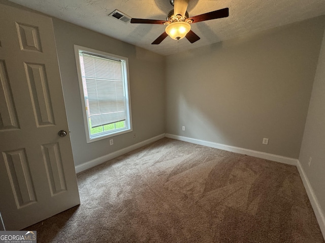 carpeted empty room featuring a textured ceiling and ceiling fan