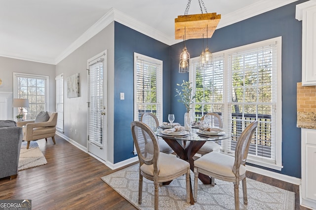 dining room with dark hardwood / wood-style flooring, ornamental molding, and a chandelier