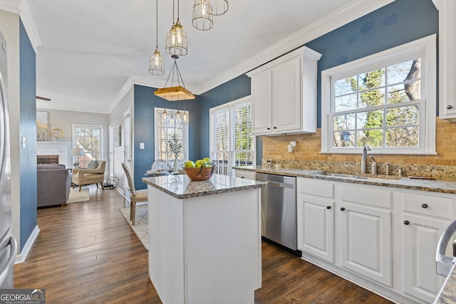 kitchen featuring white cabinets, dishwasher, a center island, hanging light fixtures, and light stone counters