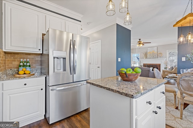 kitchen with a center island, white cabinetry, a fireplace, stainless steel fridge with ice dispenser, and ceiling fan