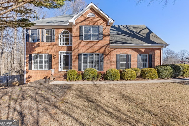 colonial-style house featuring a front lawn