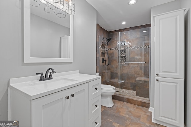 bathroom featuring toilet, vanity, and walk in shower