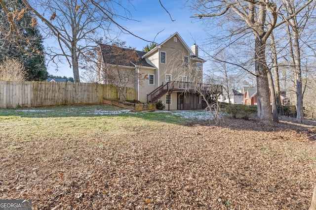 rear view of property with a lawn and a wooden deck