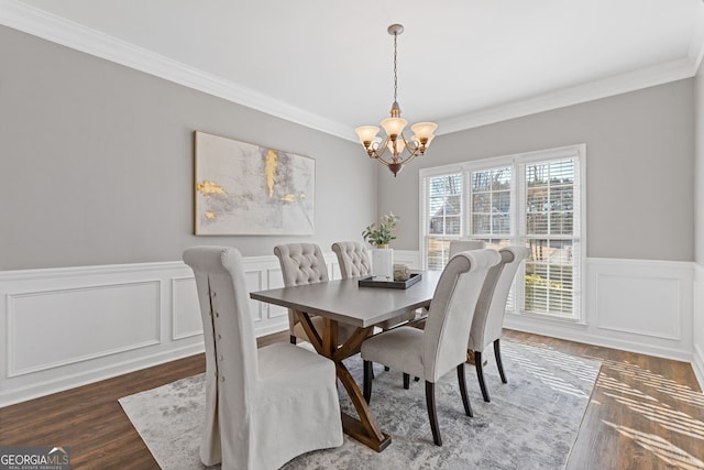 dining area with dark hardwood / wood-style floors, ornamental molding, and a notable chandelier