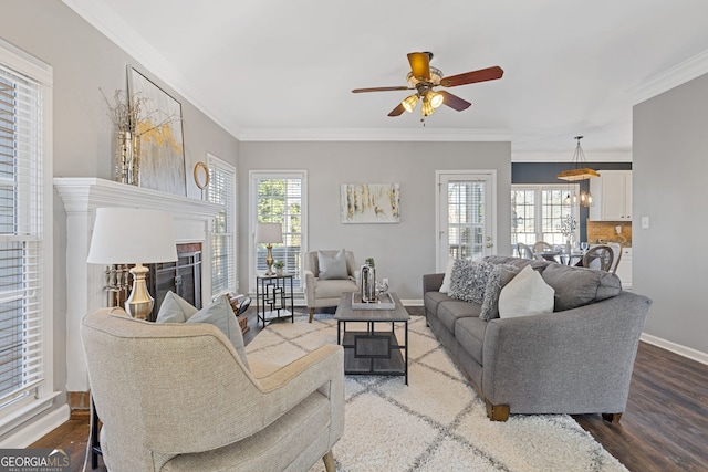 living room featuring ceiling fan, ornamental molding, hardwood / wood-style floors, and a brick fireplace