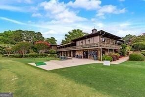 rear view of property featuring a patio area and a yard