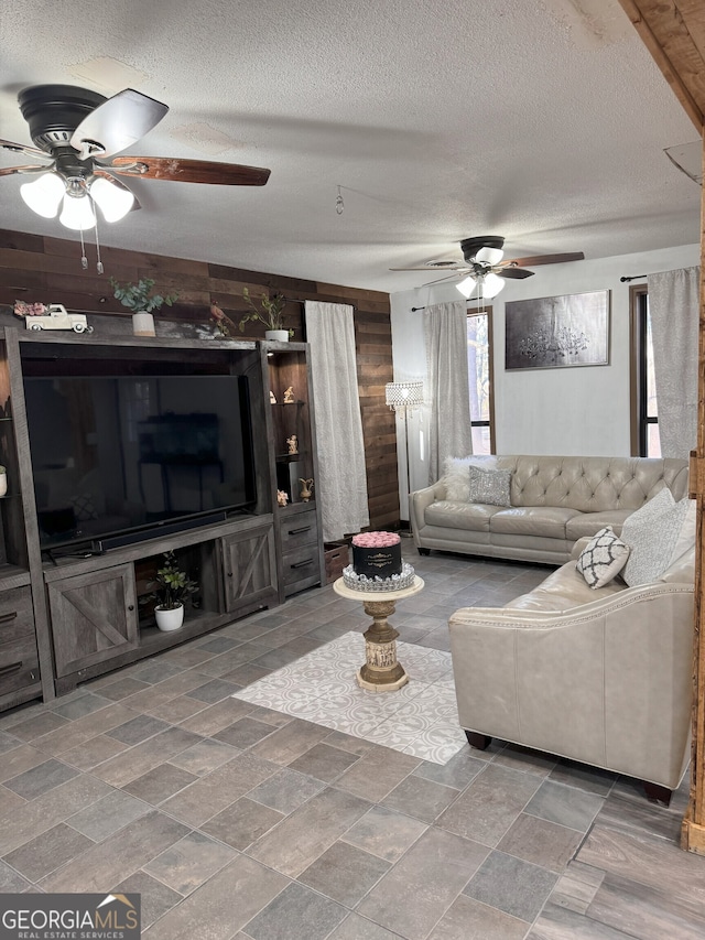 living room featuring a textured ceiling and wood walls