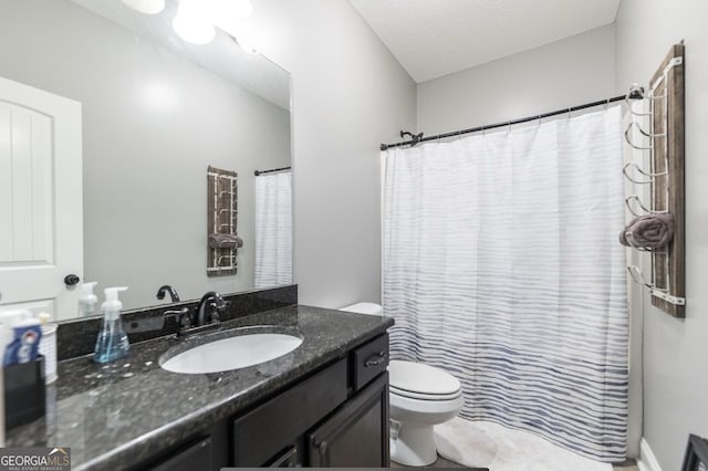 bathroom with vanity, a textured ceiling, and toilet