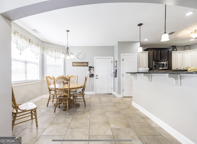 dining area featuring a chandelier and light tile patterned floors