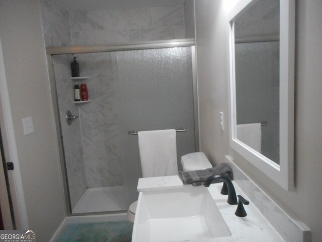 bathroom featuring toilet, an enclosed shower, and vanity