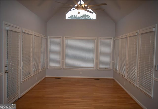 unfurnished sunroom with ceiling fan and vaulted ceiling