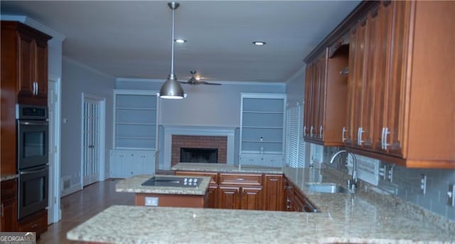 kitchen featuring light stone countertops, tasteful backsplash, stainless steel double oven, sink, and a kitchen island